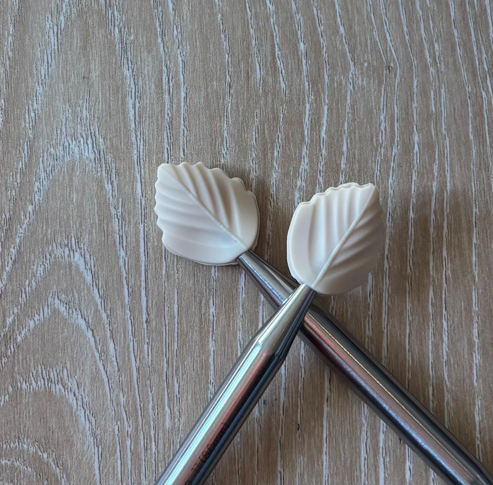 Leaf needle stoppers for knitting needles