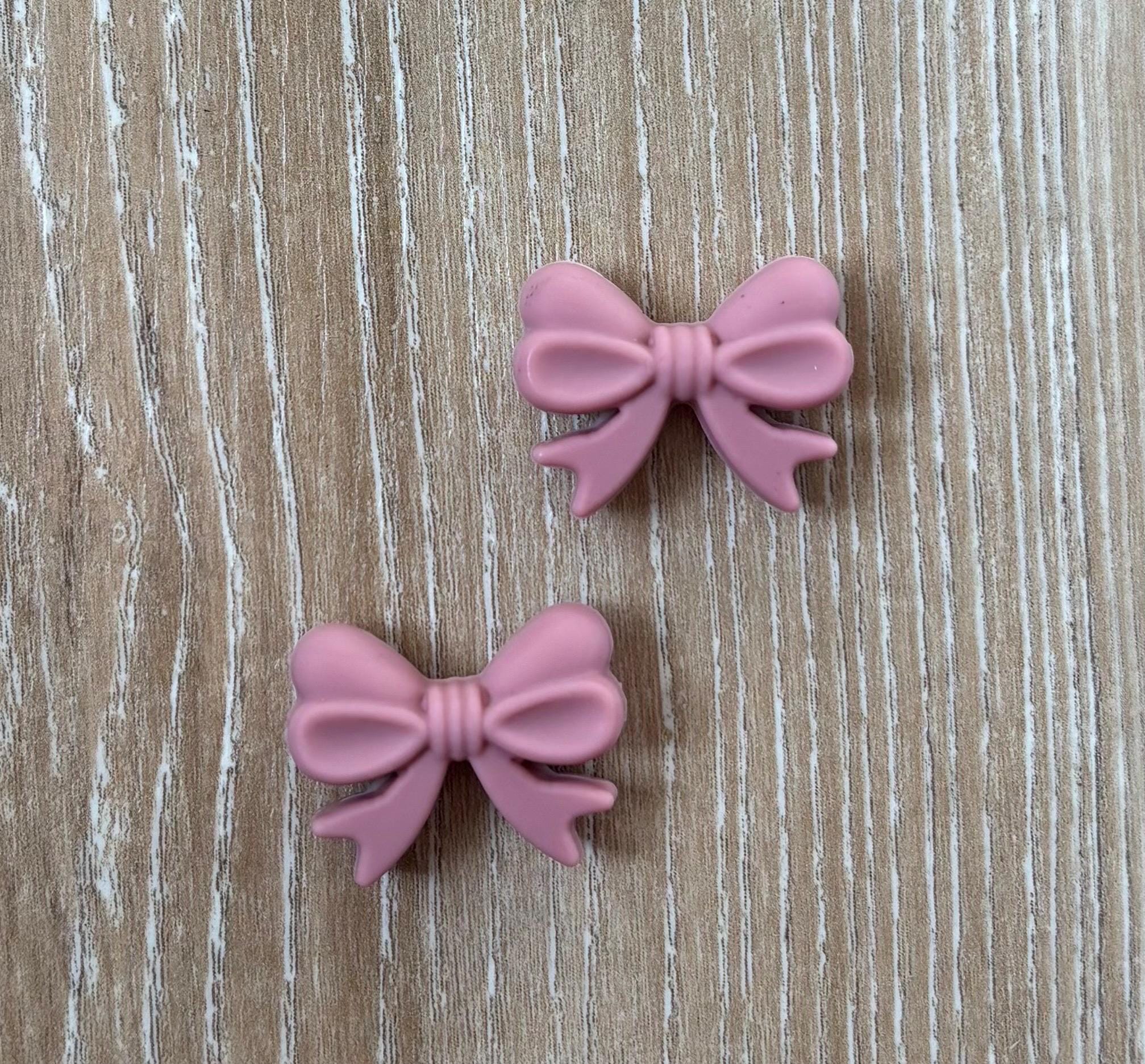 Bow needle stoppers for knitting needles