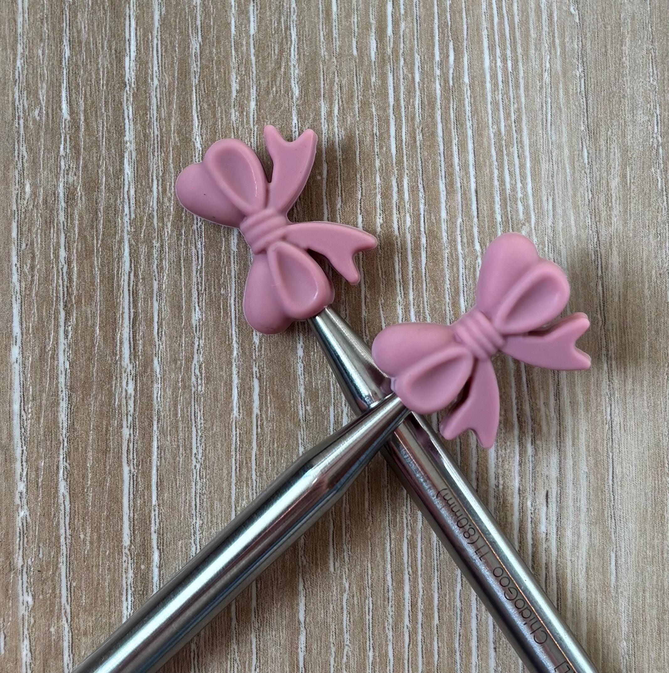 Bow needle stoppers for knitting needles