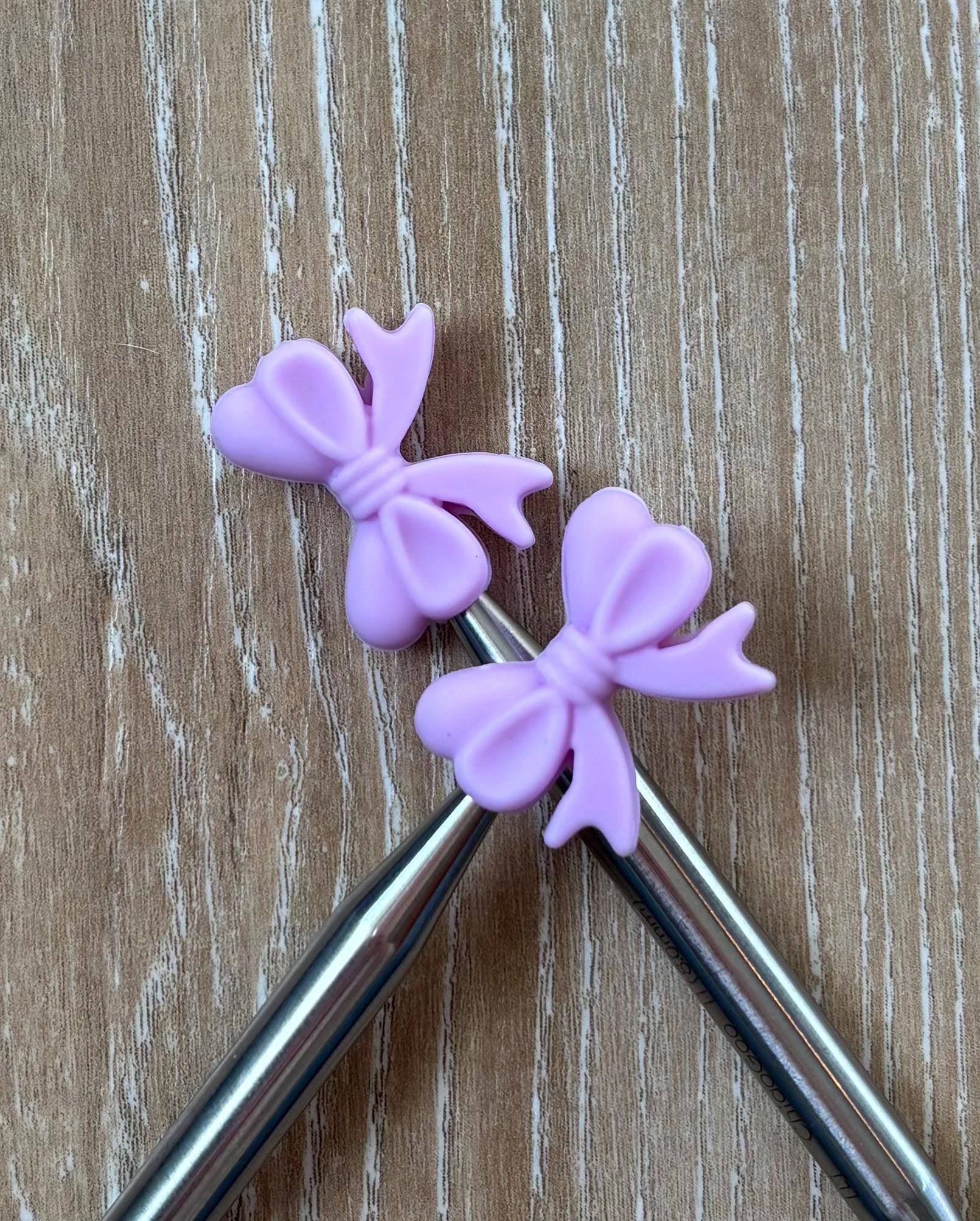 Bow needle stoppers for knitting needles