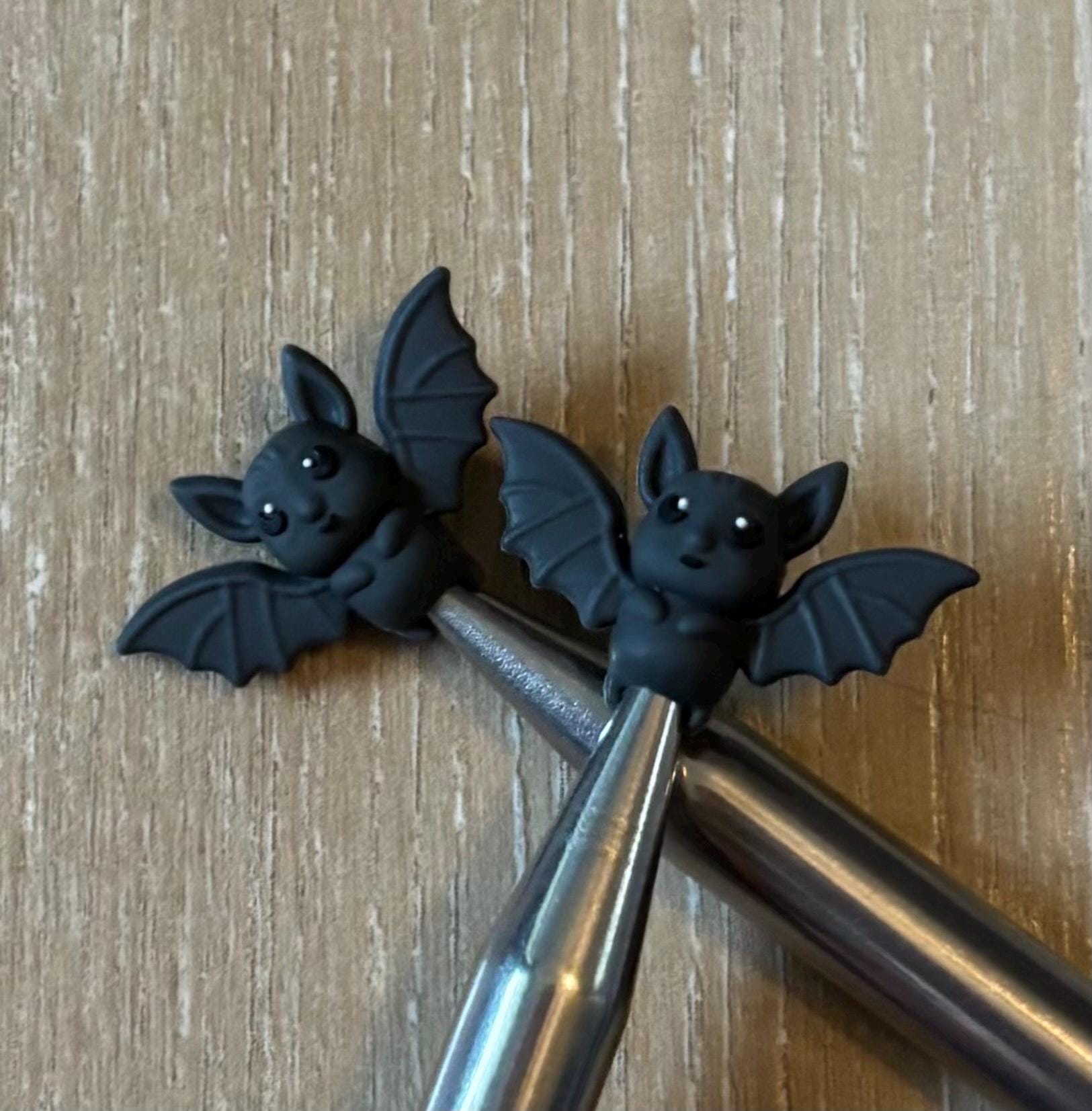 Bat needle stoppers for knitting needles