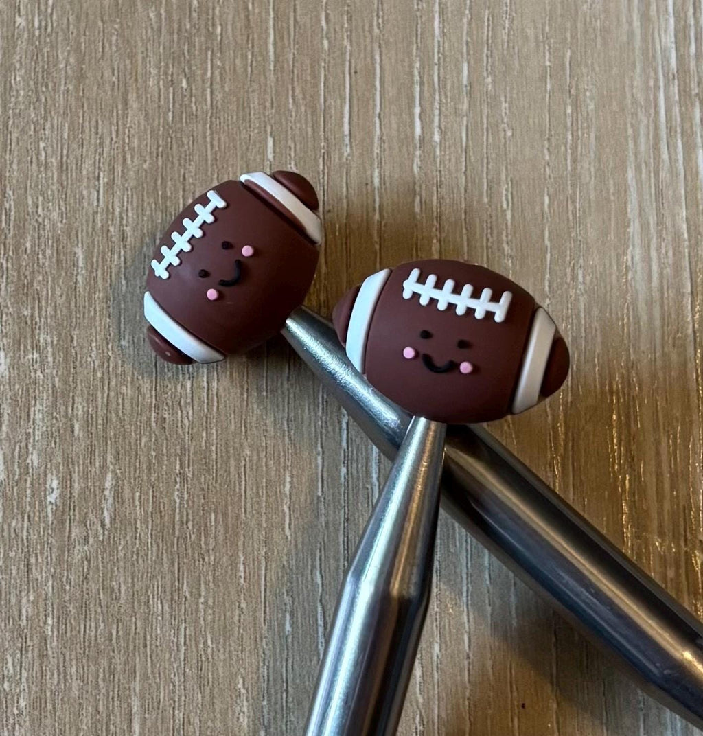 Football needle stoppers for knitting needles