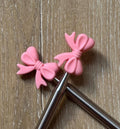 Bow needle stoppers for knitting needles