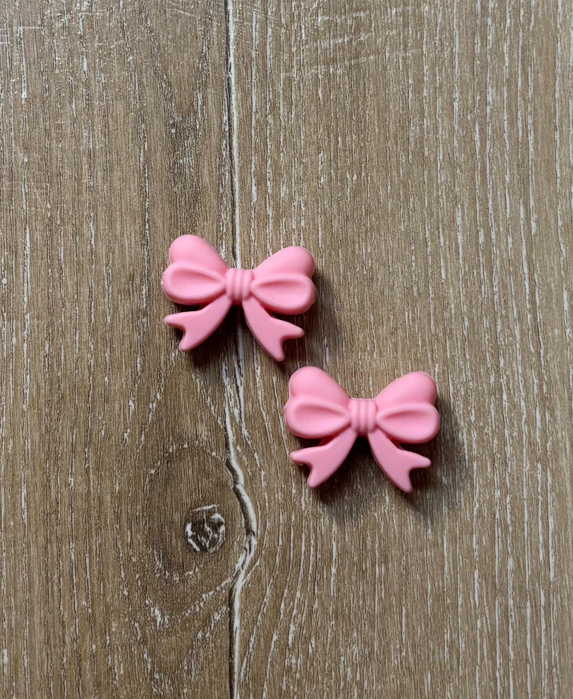 Bow needle stoppers for knitting needles